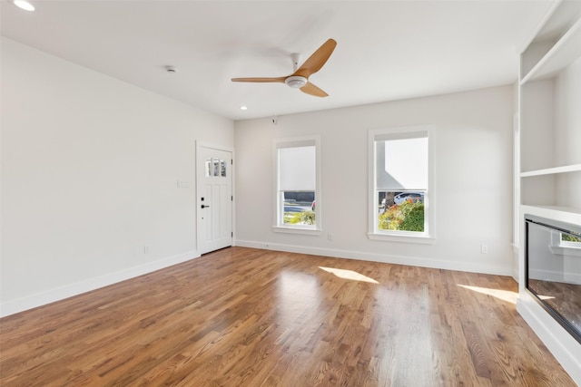 unfurnished living room with ceiling fan and hardwood / wood-style floors