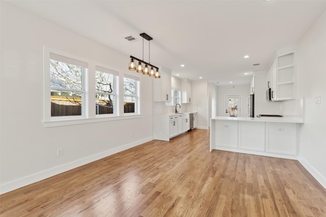 unfurnished living room with sink and light hardwood / wood-style flooring