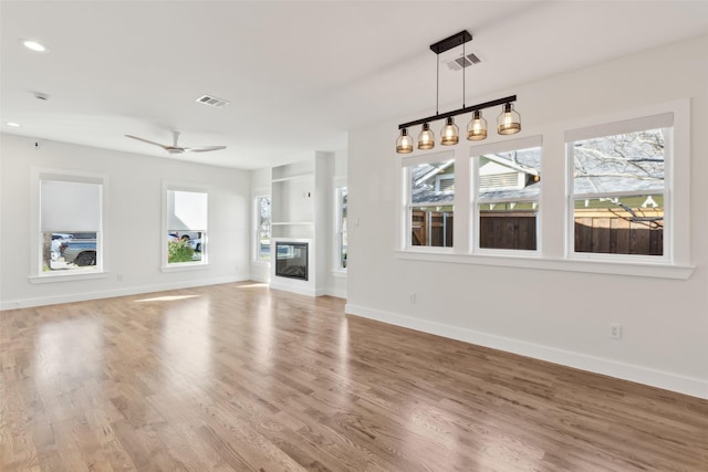 unfurnished living room featuring hardwood / wood-style flooring and ceiling fan