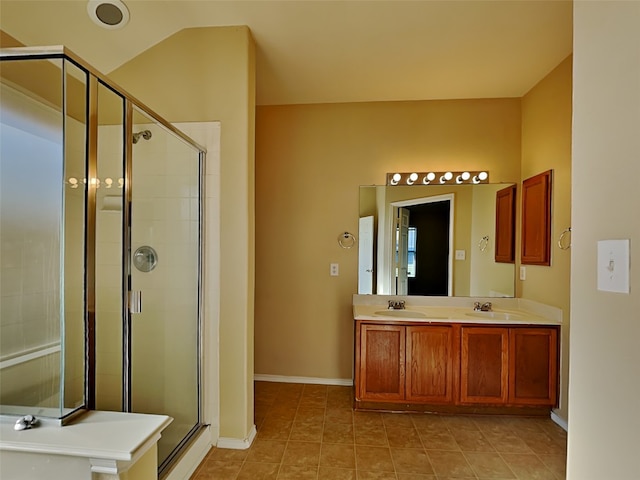 bathroom with tile patterned flooring, vanity, and walk in shower