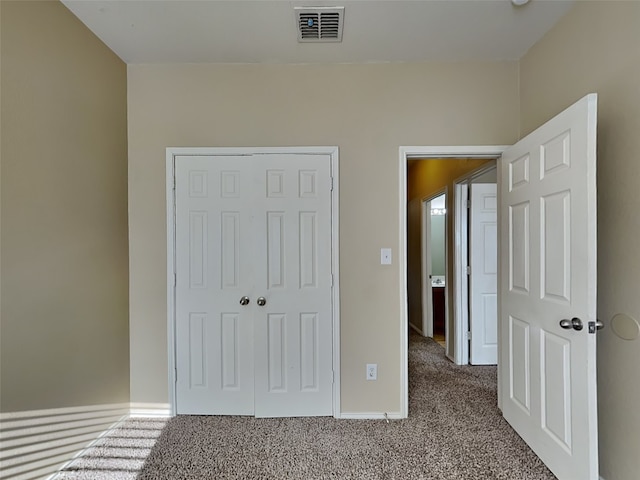 unfurnished bedroom featuring carpet and a closet