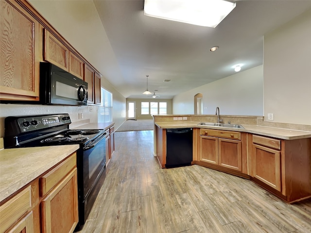 kitchen featuring ceiling fan, sink, light hardwood / wood-style flooring, kitchen peninsula, and black appliances