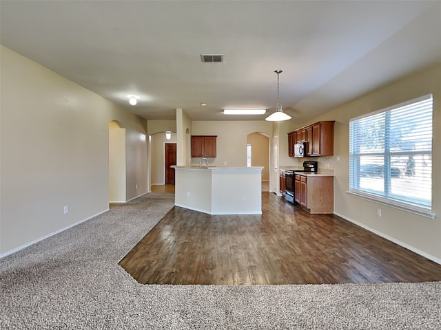 kitchen featuring sink, dark colored carpet, black range with electric cooktop, decorative light fixtures, and a kitchen island