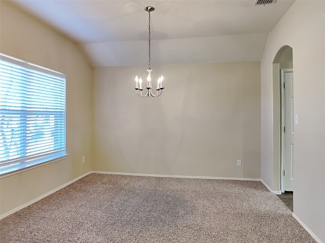 empty room with carpet floors, lofted ceiling, and a notable chandelier