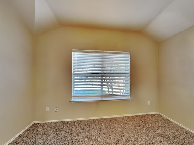 carpeted empty room with vaulted ceiling