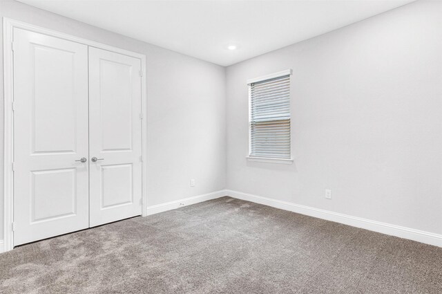 unfurnished bedroom featuring carpet floors and a closet