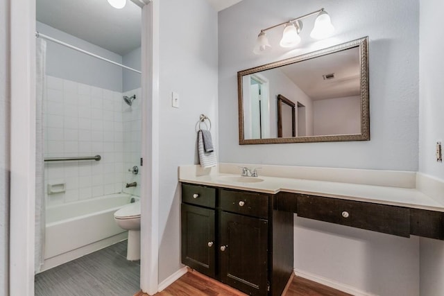 full bathroom featuring vanity, toilet, wood-type flooring, and tiled shower / bath combo