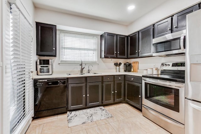 kitchen featuring sink, light tile patterned floors, stainless steel appliances, and dark brown cabinetry