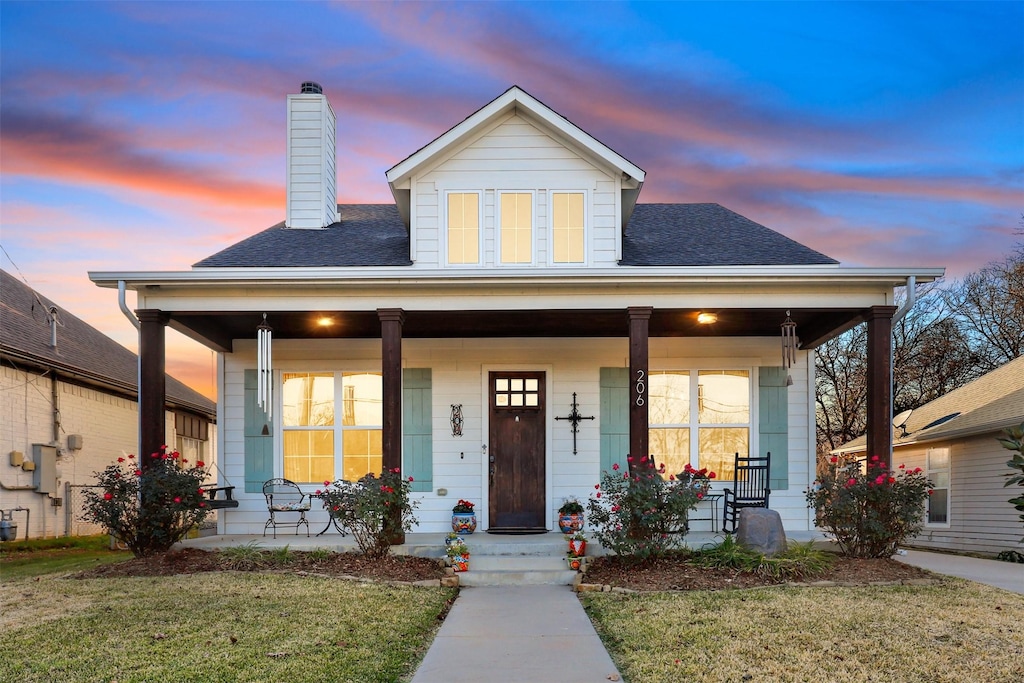 view of front of house with a lawn and a porch