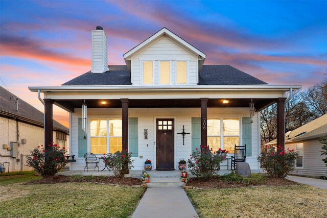 view of front facade with covered porch and a yard