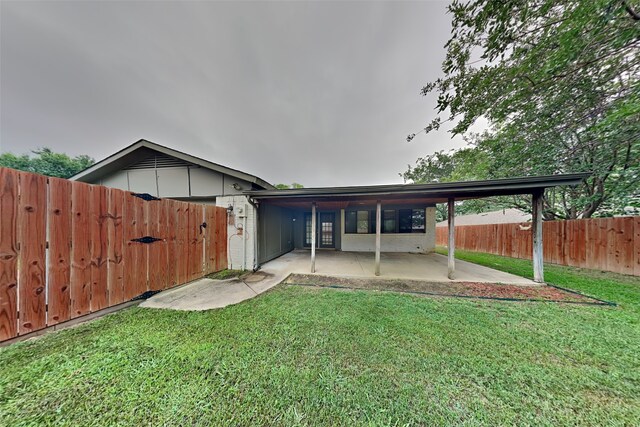 rear view of house featuring a patio and a yard