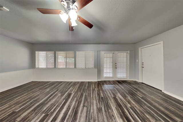 unfurnished living room featuring dark hardwood / wood-style flooring, ceiling fan, french doors, and a textured ceiling