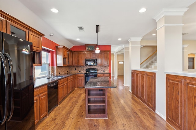 kitchen featuring sink, a center island, hanging light fixtures, decorative columns, and black appliances