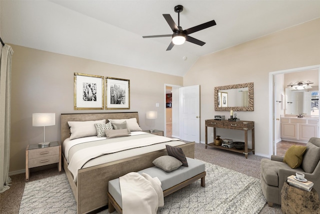 bedroom featuring vaulted ceiling, sink, light colored carpet, ceiling fan, and ensuite bath