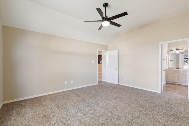 unfurnished bedroom with lofted ceiling, sink, ceiling fan, ensuite bathroom, and light carpet