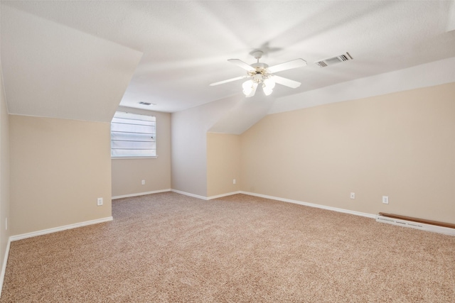 additional living space with baseboard heating, ceiling fan, vaulted ceiling, and carpet