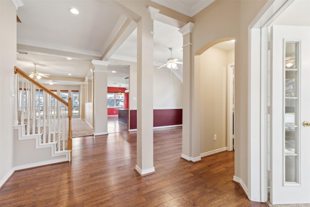 entryway featuring ceiling fan, ornamental molding, dark hardwood / wood-style flooring, and ornate columns