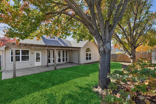 back of property with a yard and a patio area