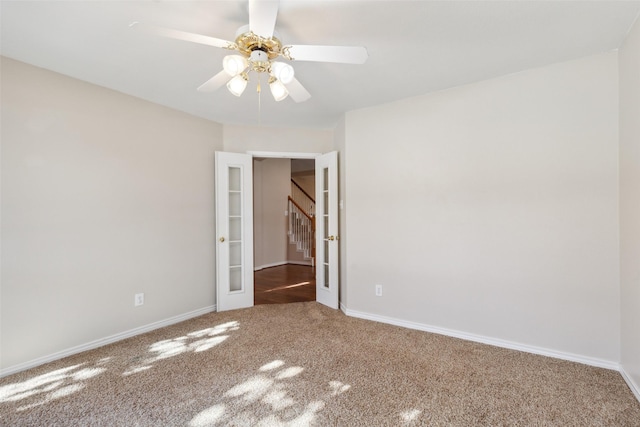 empty room featuring french doors, ceiling fan, and carpet flooring