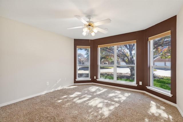 spare room featuring ceiling fan and carpet