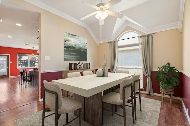 dining area featuring lofted ceiling, hardwood / wood-style floors, ornamental molding, and ceiling fan