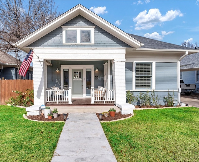 bungalow-style house featuring covered porch and a front lawn