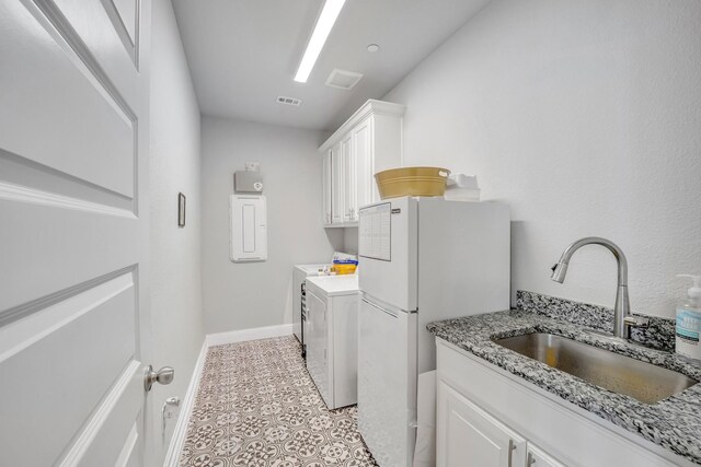 washroom with cabinets, separate washer and dryer, sink, and light tile patterned floors