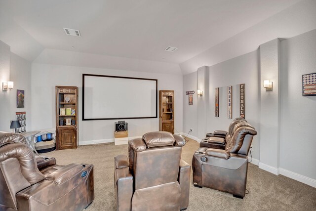 cinema featuring light carpet and vaulted ceiling