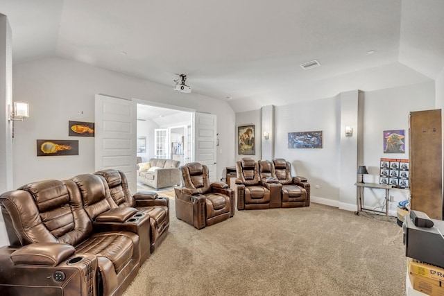 carpeted home theater room with vaulted ceiling