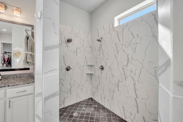 bathroom featuring a tile shower and vanity