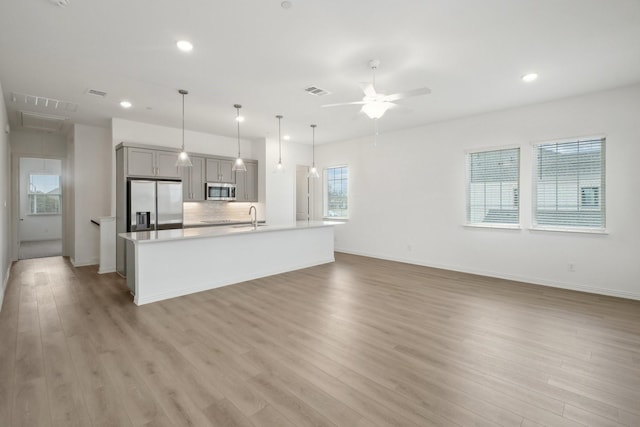 2402 Bulin Dr, Mansfield, TX 76063 - kitchen featuring light countertops, ceiling fan, stainless steel appliances, tasteful backsplash, and gray cabinets