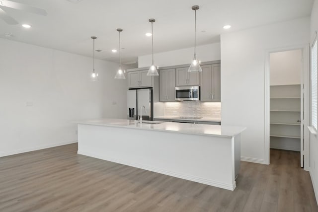 2402 Bulin Dr, Mansfield, TX 76063 - kitchen with light countertops, gray cabinetry, a sink, a kitchen island with sink, and appliances with stainless steel finishes