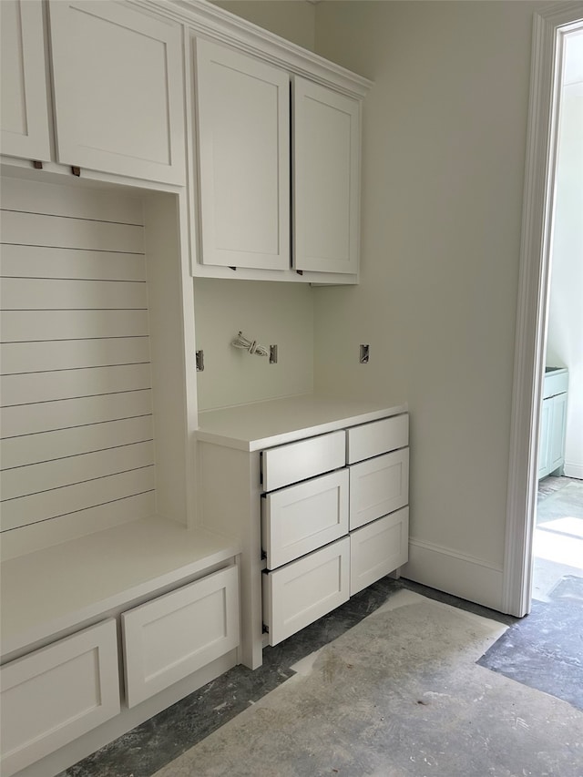 mudroom featuring baseboards and unfinished concrete flooring