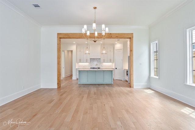 2129 Pecan Square Ave, Shreveport, LA 71106 - kitchen featuring a chandelier, backsplash, light countertops, white cabinetry, and ornamental molding