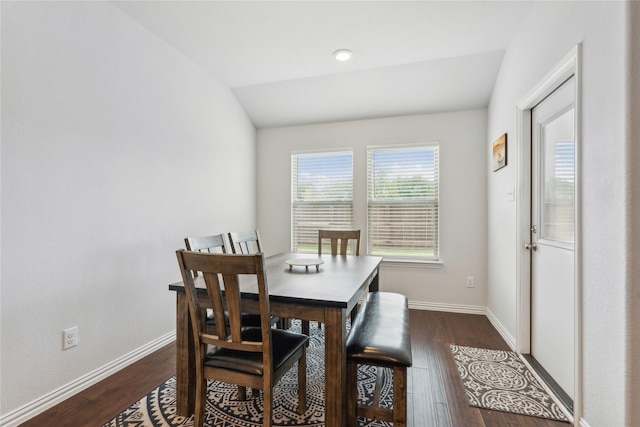 dining area with dark hardwood / wood-style floors and vaulted ceiling