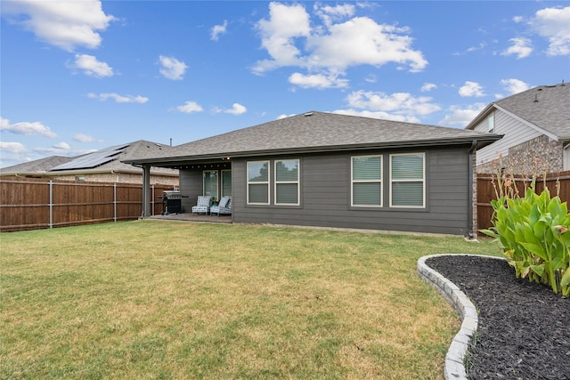 back of house with a patio and a lawn