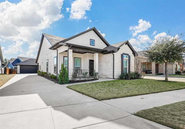 view of front of property with a front yard, a porch, and a garage