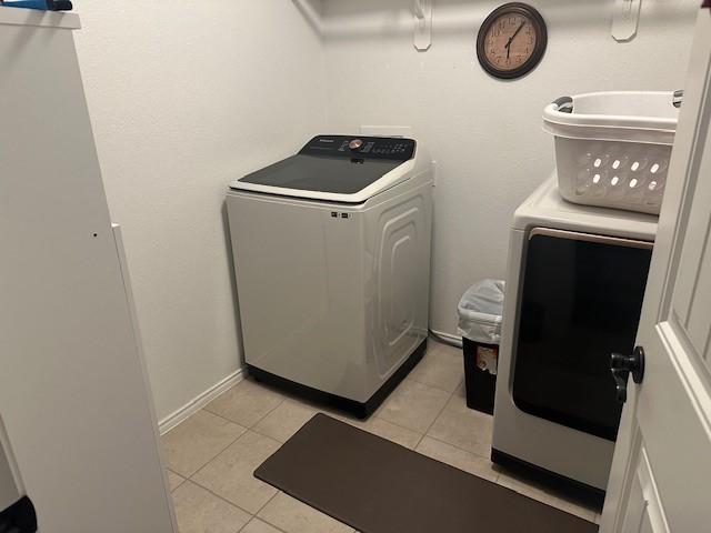 washroom featuring washer and dryer and light tile patterned floors