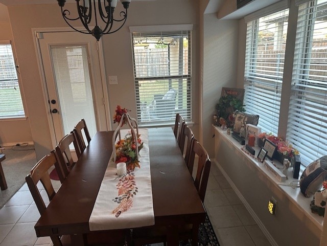 tiled dining area with an inviting chandelier and plenty of natural light