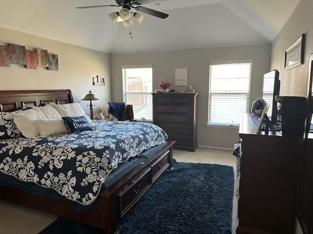 bedroom with carpet flooring, multiple windows, ceiling fan, and lofted ceiling