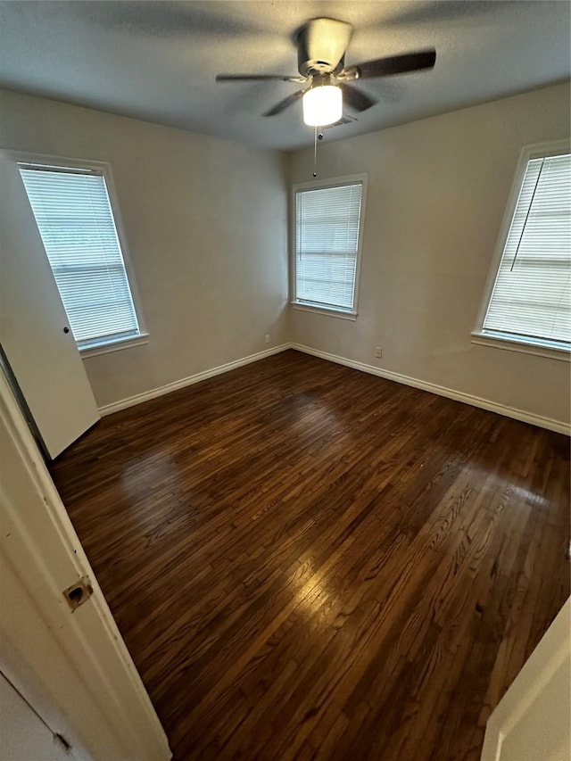 spare room featuring dark hardwood / wood-style flooring and ceiling fan