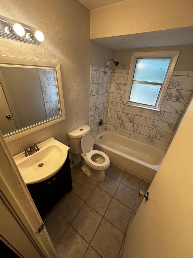 full bathroom featuring tile patterned floors, vanity, tiled shower / bath combo, and toilet