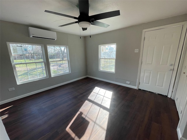 spare room with plenty of natural light, ceiling fan, dark wood-type flooring, and a wall mounted AC