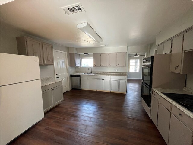 unfurnished room featuring dark wood-type flooring, a wall unit AC, and ceiling fan