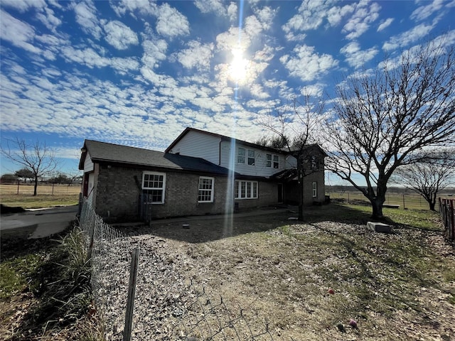 view of home's exterior with brick siding and fence