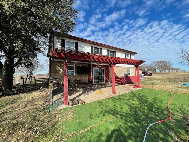 back of property with brick siding, a yard, a patio, fence, and a pergola