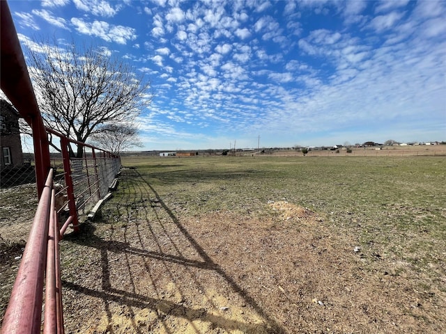 view of yard featuring a rural view and fence