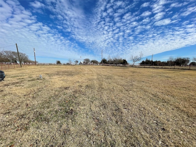 view of yard with a rural view and fence