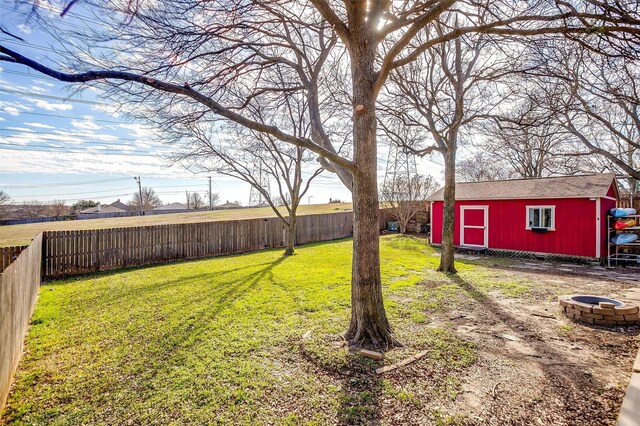 view of yard featuring an outbuilding and a fire pit