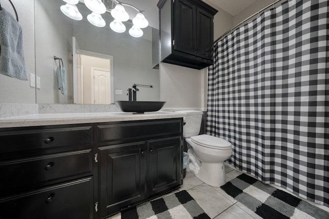 bathroom with toilet, vanity, and tile patterned floors